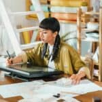 Artist works on a digital tablet in her studio