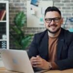 a man sitting at a table with a laptop