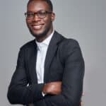 a man in a suit and glasses posing for a picture
